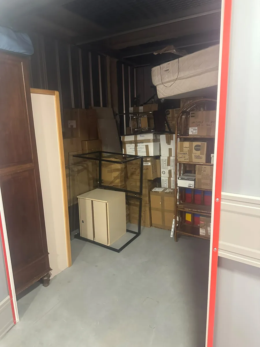 Réserve encombrée de cartons et de matériel, avant le tri
